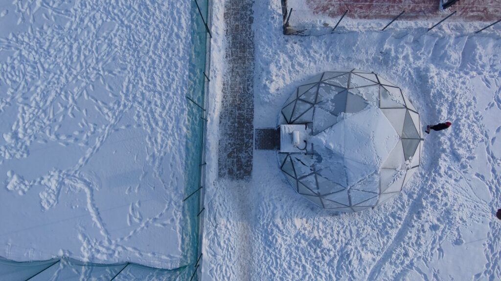 雪に覆われたガラスドームホテル。高い耐雪性能を備え、冬でも快適に過ごせるリゾート向けガラスドーム建築。