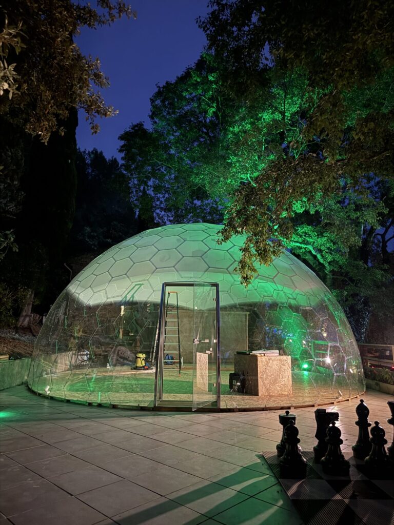 緑のライトアップに包まれた透明ガラスドーム「AURA DOME」。ホテルやリゾート、イベント施設、商業施設に非日常の空間を演出する全天候型ドーム建築。